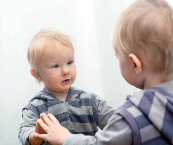 Chłopiec patrzący na swoje odbicie w lustrze