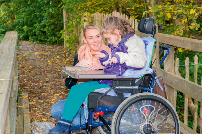 niepełnosprawna dziewczynka na wózku inwalidzkim, opiekunka, jesień, spacer